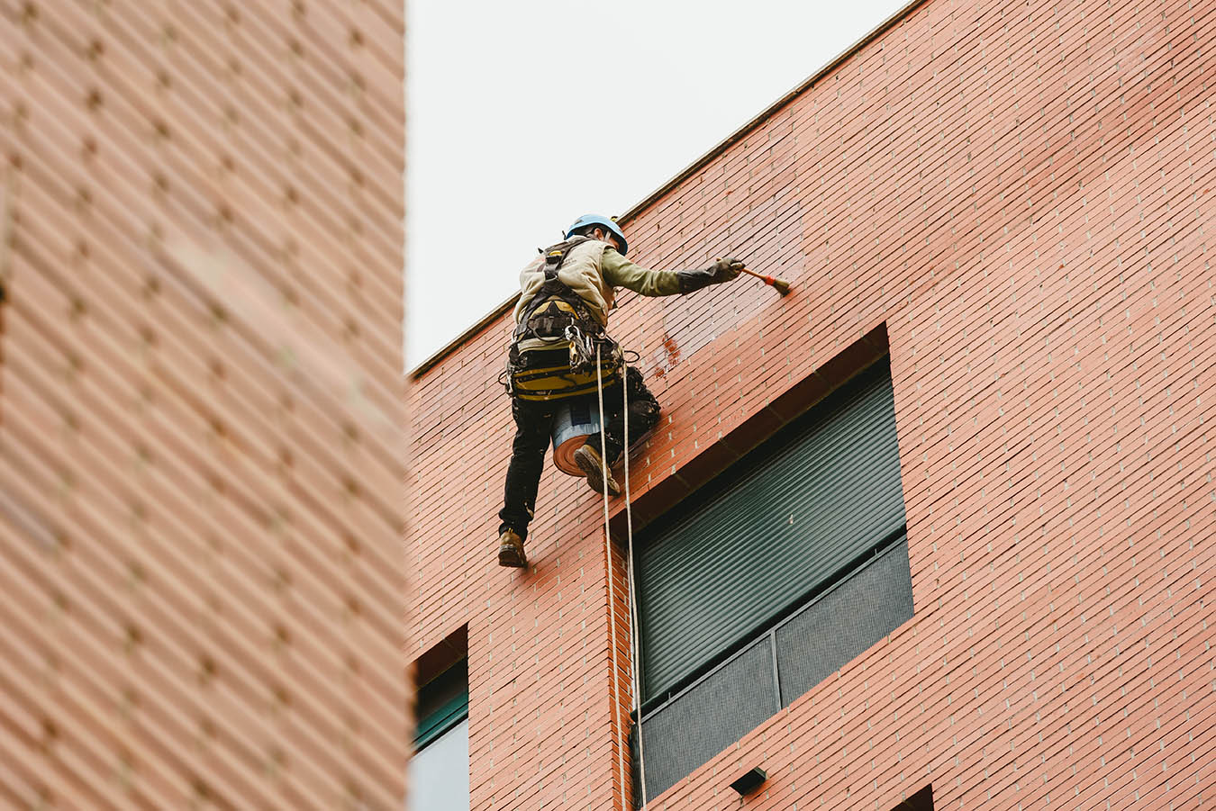 Painter perched hanging on the walls of a building with ropes.; Shutterstock ID 1317672755; Purchase Order: -